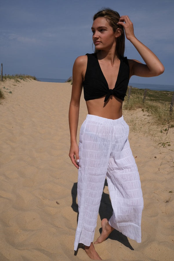 ATHENS - White Rouched. These are a pair of high-waisted trousers featuring a comfortable thick elastic waistband for easy everyday wear. The loose fit provides comfortability and easy wear, skimming the natural shape of the body with a slightly cropped leg.