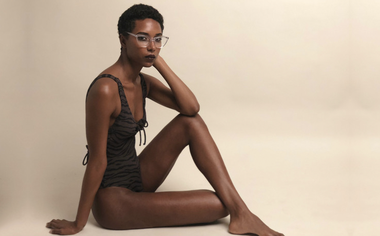 Woman sitting down wearing zebra PRISM swimsuit