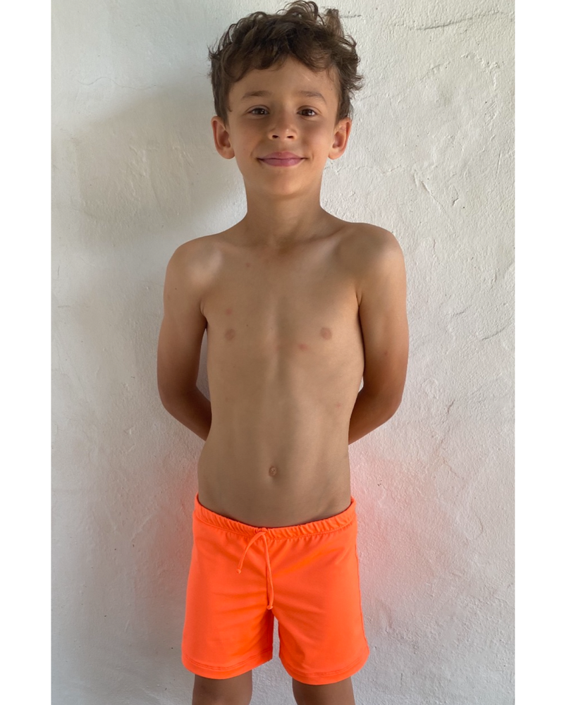 BOY'S SHORTS - Neon Orange. Where comfort is of the utmost importance for children, the shorts slip on with an elastic waistband and have 1/2 cm black waist chord-tie, they sit on the hip and fall just above the knee, at mid-thigh length.