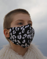 MASK - Black Leopard. Masks handmade in Italy using excess swimwear material, for sustainability. All fabric is breathable and water resistant. Every mask has its own unique design and fabric. Protect yourself, your loved ones, and the environment. This fabric is a lightweight, traditional swim fabric.